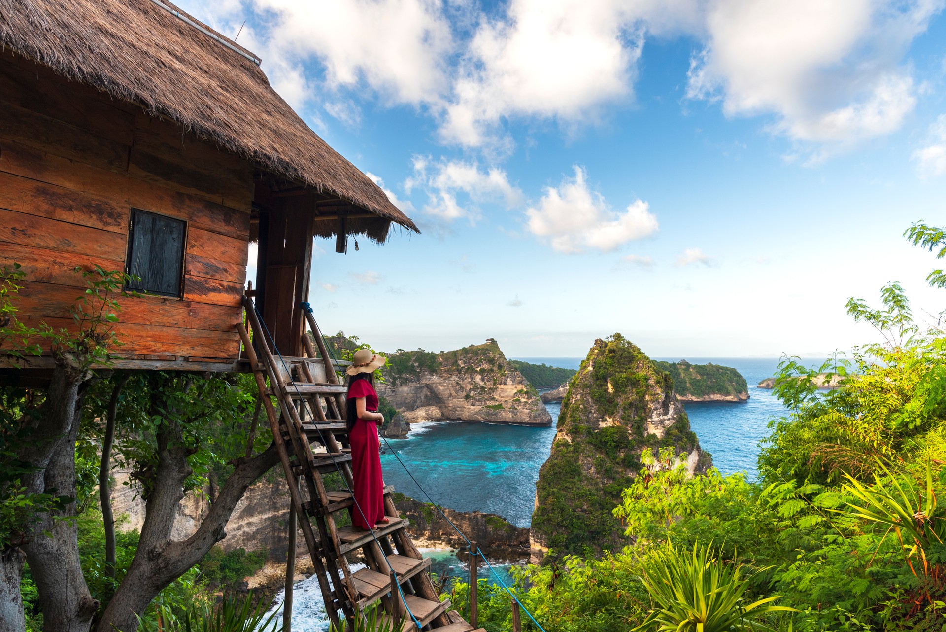 Scenic view of young woman close to the tree house looking at the sea, Nusa Penida island, Indonesia